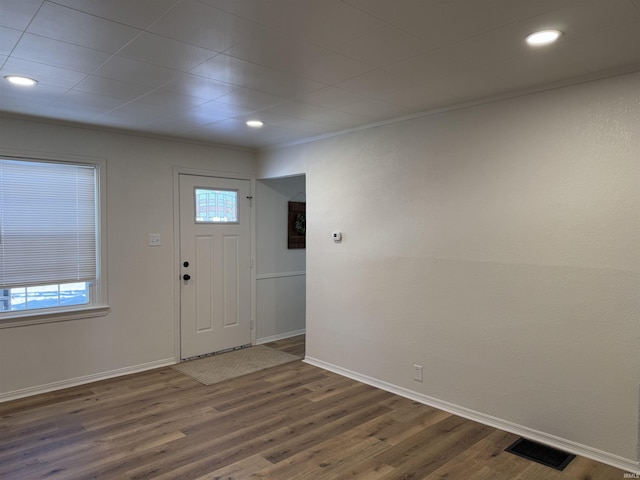 entrance foyer featuring dark hardwood / wood-style floors, crown molding, and a healthy amount of sunlight