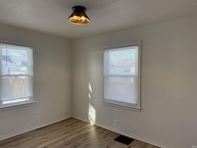 unfurnished room with wood-type flooring