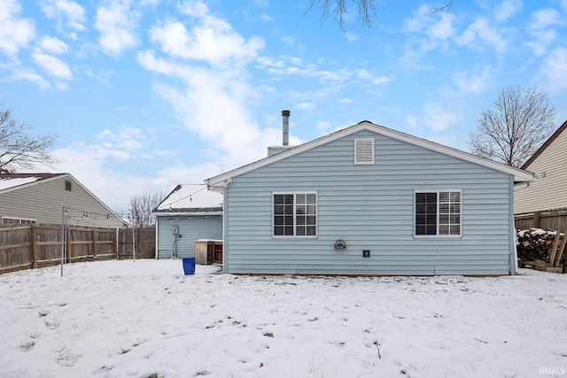 view of snow covered back of property