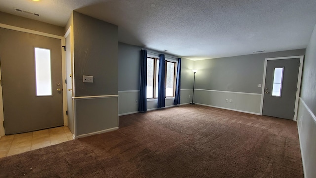 carpeted entrance foyer with a textured ceiling