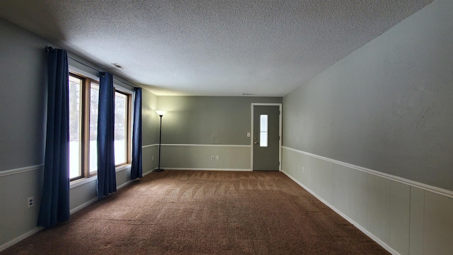 spare room with a textured ceiling and carpet floors