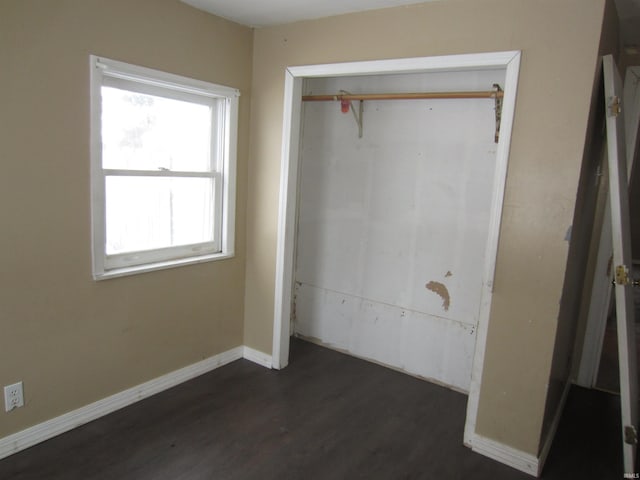 unfurnished bedroom featuring dark hardwood / wood-style floors and a closet