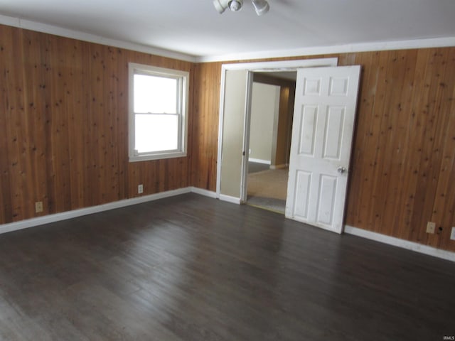 empty room featuring dark hardwood / wood-style flooring and wood walls