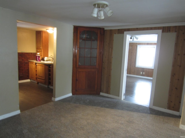 unfurnished dining area with ceiling fan, sink, and dark carpet