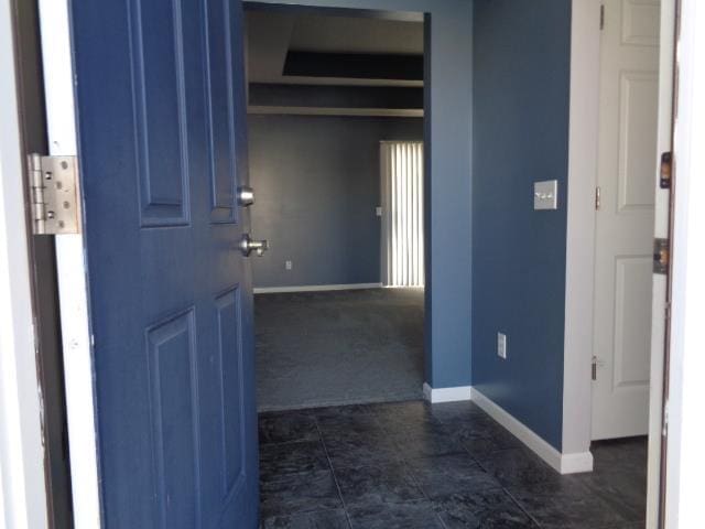 hallway featuring dark colored carpet