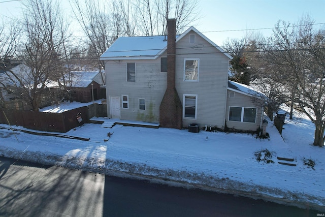 view of snow covered back of property