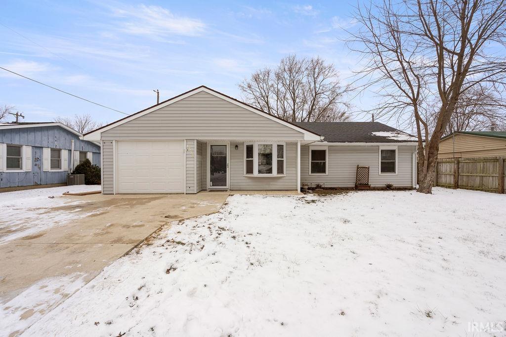 view of front of home featuring a garage and central AC