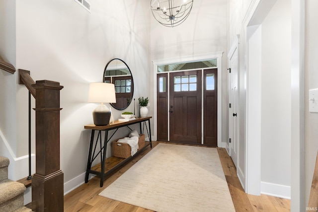 foyer featuring an inviting chandelier and light hardwood / wood-style flooring