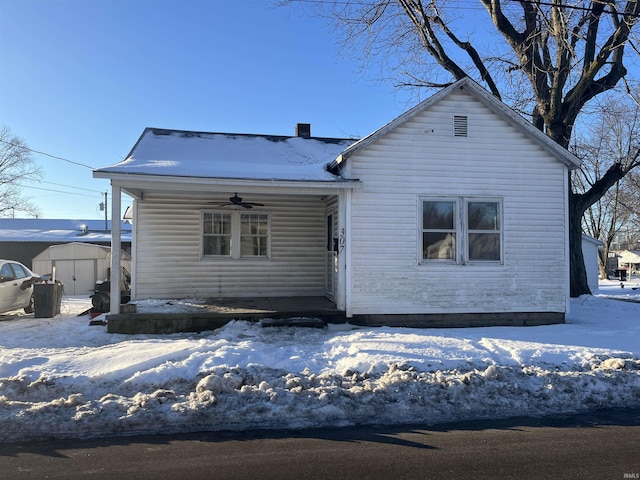 view of front of home featuring ceiling fan, a porch, and a storage unit