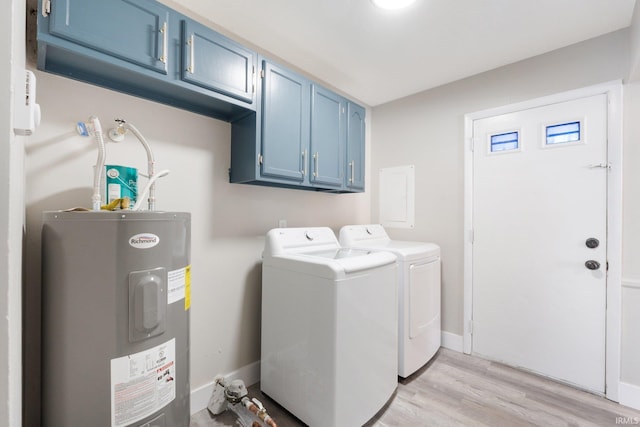 laundry room featuring washer and dryer, cabinets, water heater, and light wood-type flooring