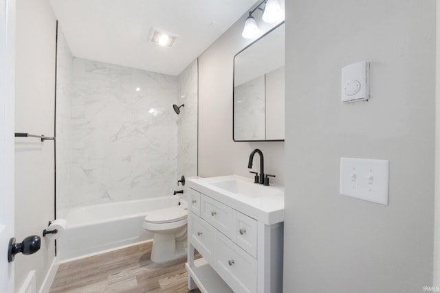 full bathroom featuring toilet, tiled shower / bath combo, wood-type flooring, and vanity