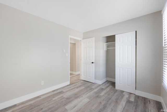 unfurnished bedroom featuring light wood-type flooring and a closet