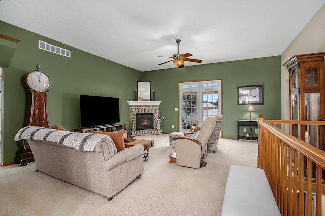 carpeted living room with ceiling fan and a fireplace