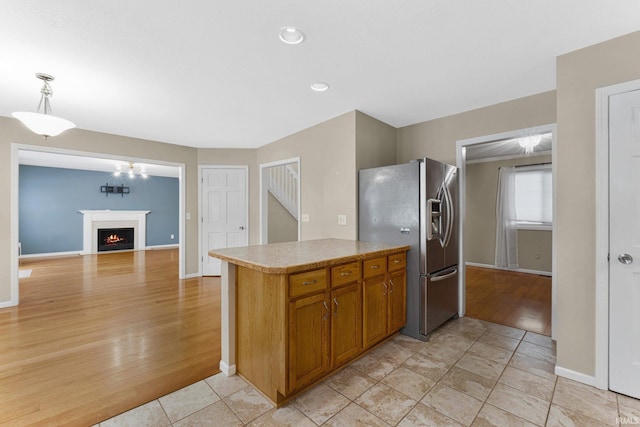 kitchen featuring hanging light fixtures, stainless steel refrigerator with ice dispenser, and light tile patterned flooring