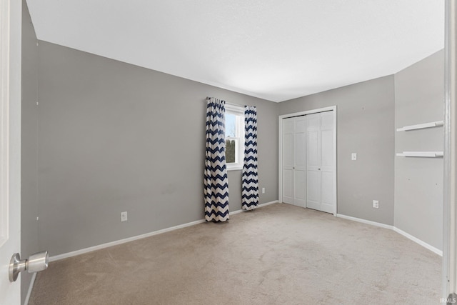 unfurnished bedroom featuring a closet and light colored carpet