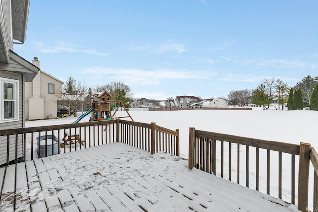 snow covered deck with a playground