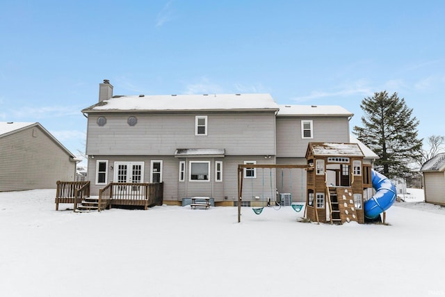 snow covered property with a deck and cooling unit