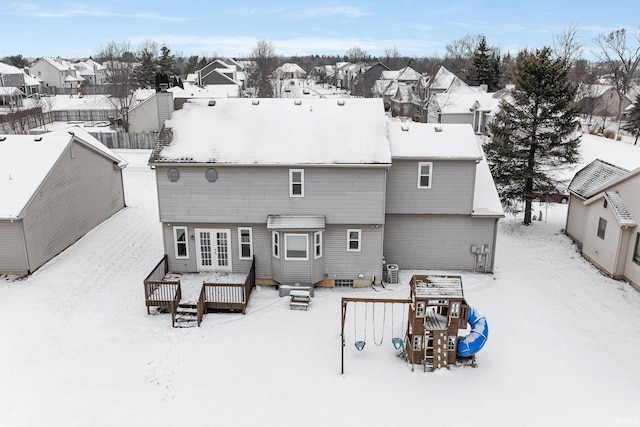 snow covered rear of property with central AC and a wooden deck