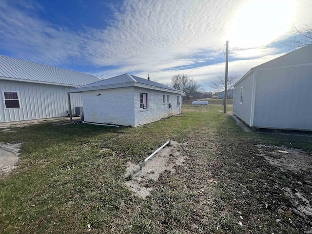 view of side of property with a lawn and central air condition unit