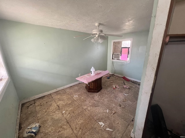 bathroom with ceiling fan and a textured ceiling