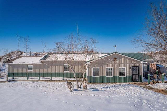 view of snow covered back of property