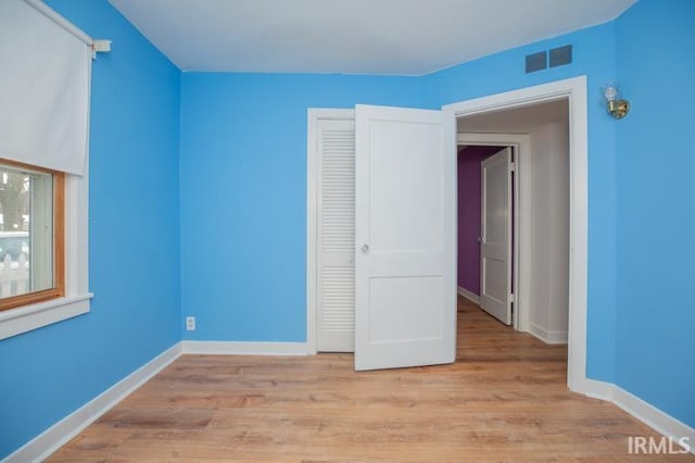 unfurnished bedroom featuring a closet and light hardwood / wood-style floors