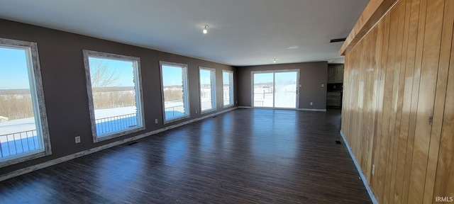 unfurnished room with dark hardwood / wood-style floors and wood walls