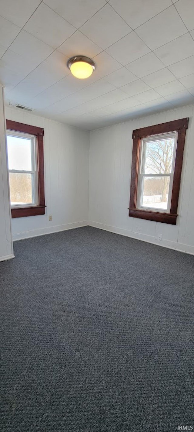 unfurnished room with dark colored carpet