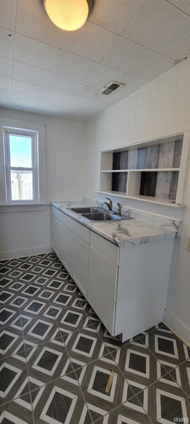 kitchen featuring white cabinets and sink