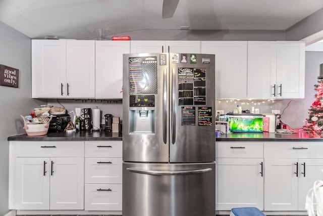 kitchen featuring decorative backsplash, stainless steel fridge, and white cabinetry