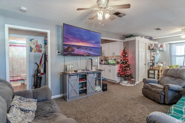 carpeted living room featuring a textured ceiling and ceiling fan