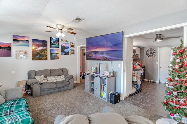 living room featuring vaulted ceiling, ceiling fan, and a textured ceiling