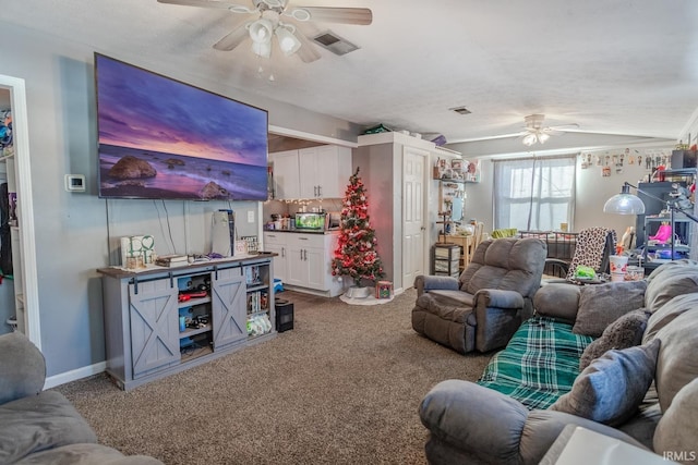 carpeted living room with ceiling fan, vaulted ceiling, and a textured ceiling