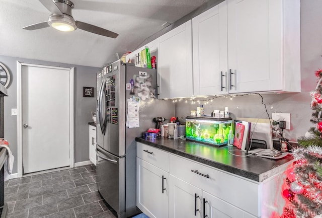 kitchen featuring ceiling fan, backsplash, white cabinetry, and stainless steel fridge