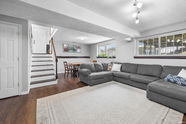 living room featuring dark wood-type flooring and a textured ceiling