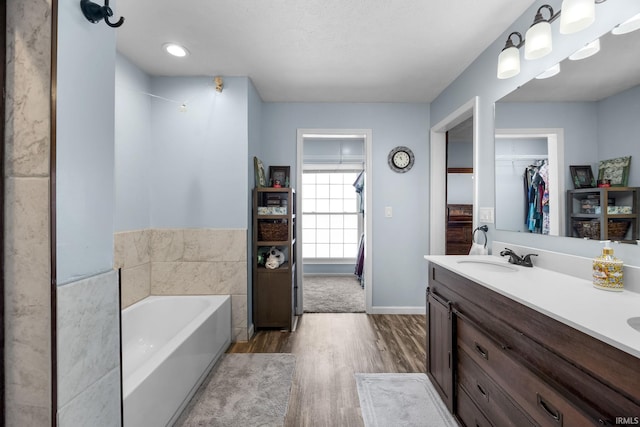 bathroom featuring a tub to relax in, vanity, a textured ceiling, and hardwood / wood-style flooring