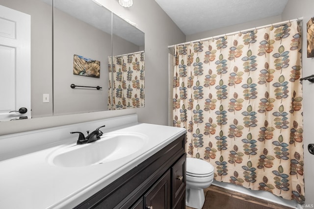 bathroom with curtained shower, a textured ceiling, toilet, and vanity