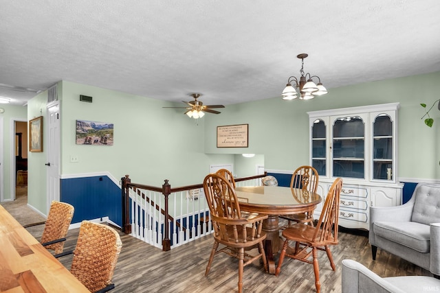 dining room featuring a textured ceiling, ceiling fan with notable chandelier, and hardwood / wood-style flooring