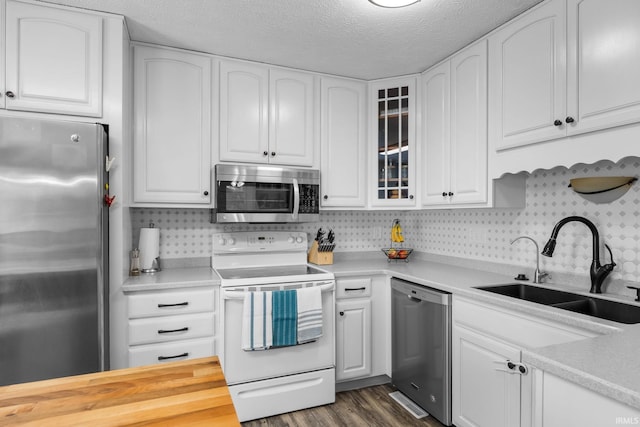 kitchen with decorative backsplash, sink, white cabinetry, appliances with stainless steel finishes, and a textured ceiling