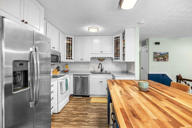 kitchen featuring sink, white cabinets, stainless steel appliances, and wooden counters