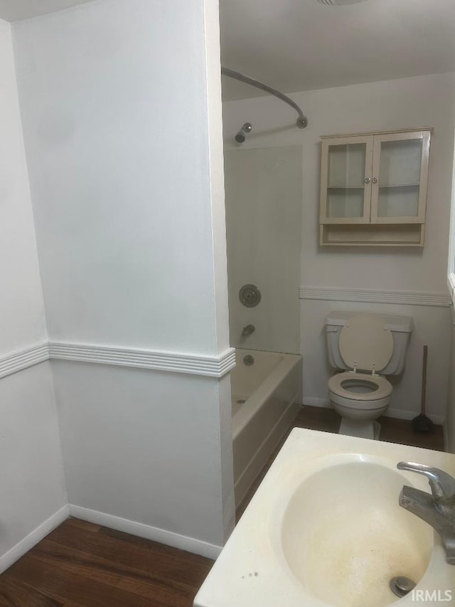 full bathroom with hardwood / wood-style flooring, sink, bathtub / shower combination, and toilet