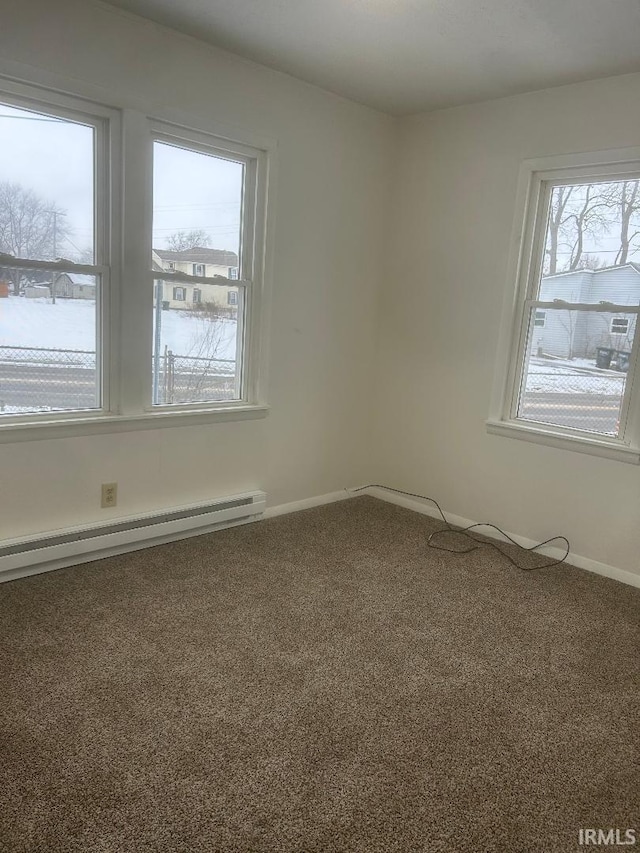 unfurnished room with a baseboard heating unit and carpet