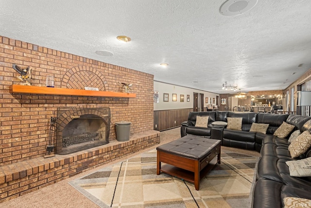 living room with a fireplace, a textured ceiling, carpet, and wooden walls