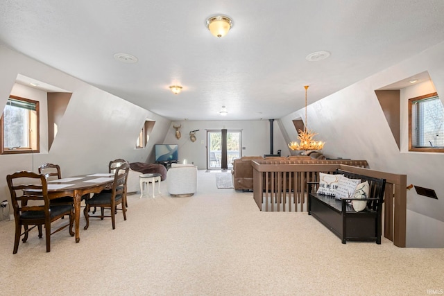 interior space featuring lofted ceiling, carpet floors, and an inviting chandelier