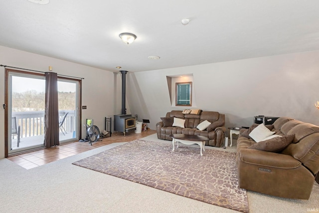 living room featuring light carpet and a wood stove