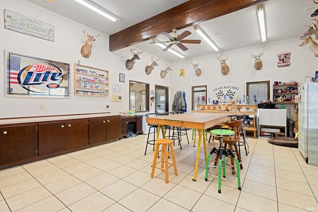 dining room featuring beam ceiling, light tile patterned floors, and ceiling fan