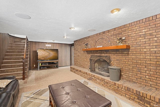 living room with a fireplace, wooden walls, and a textured ceiling