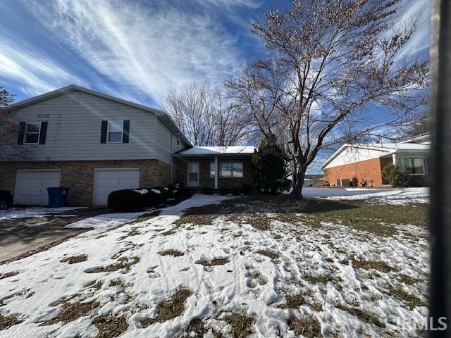 snow covered property featuring a garage