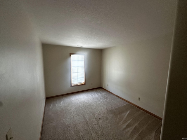 carpeted empty room with a textured ceiling