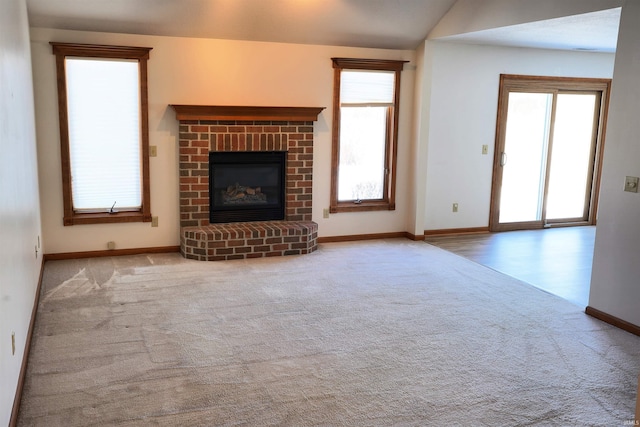 unfurnished living room with light carpet, a fireplace, and lofted ceiling